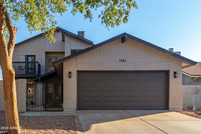 view of front facade with a balcony, a garage, and central AC unit