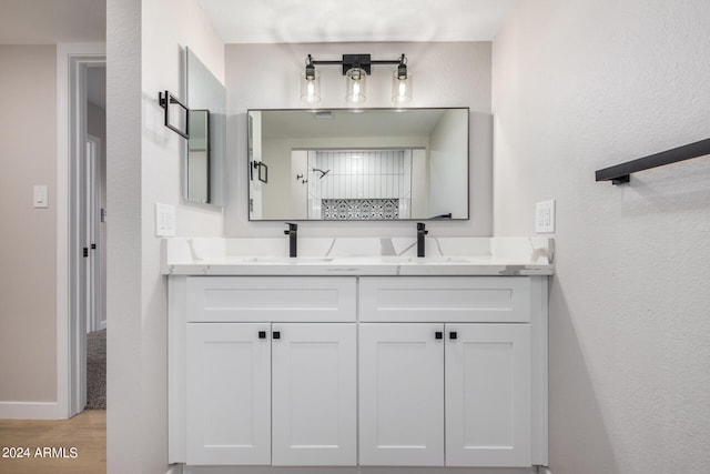 bathroom featuring wood-type flooring, vanity, and walk in shower