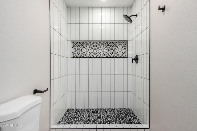 bathroom with tiled shower and toilet