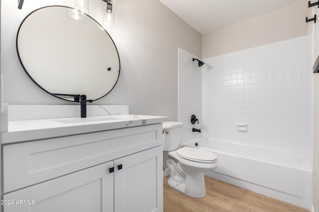 full bathroom featuring vanity, tiled shower / bath combo, toilet, and hardwood / wood-style flooring