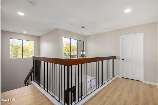 corridor featuring a notable chandelier and light hardwood / wood-style flooring