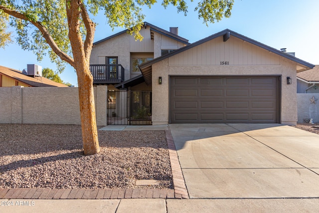 view of front of property featuring a balcony, a garage, and central AC