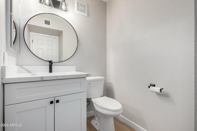 bathroom featuring hardwood / wood-style flooring, vanity, and toilet