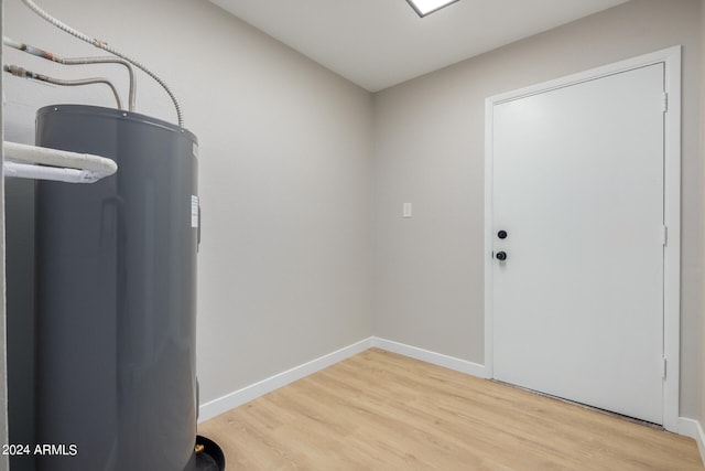 laundry room with water heater and wood-type flooring