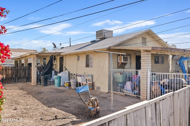 11507 N 79th Dr, Peoria, AZ 85345 - rear view of property featuring stucco siding, a wall mounted air conditioner, and fence