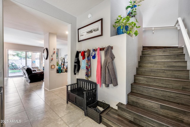 stairway with tile patterned flooring and baseboards