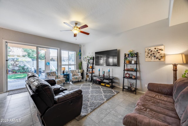 tiled living room with a ceiling fan and baseboards