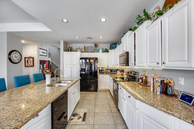 kitchen with black appliances, a sink, white cabinetry, recessed lighting, and light stone countertops