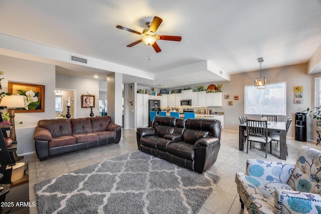 living area featuring light tile patterned floors, ceiling fan, and plenty of natural light