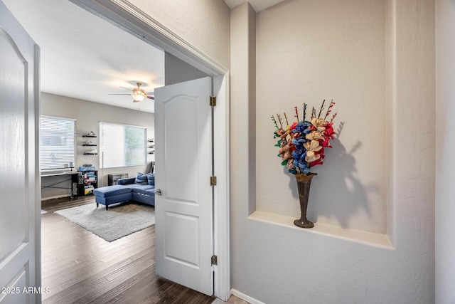 hallway featuring wood finished floors and baseboards