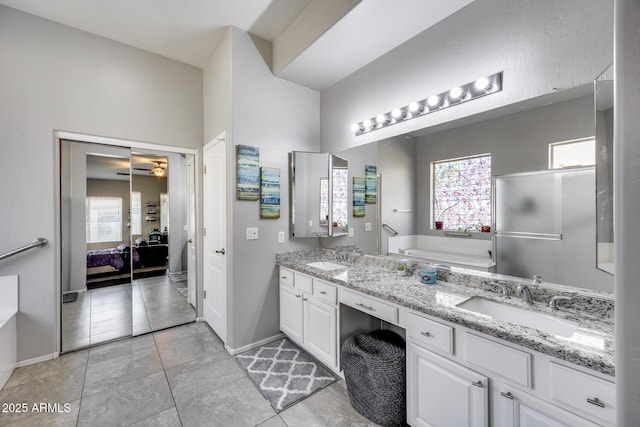 full bathroom with ensuite bathroom, a bath, double vanity, tile patterned flooring, and ceiling fan