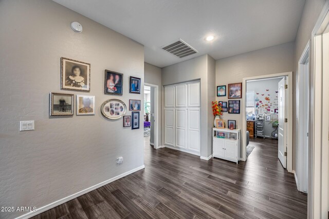 hall featuring dark wood-style floors and baseboards