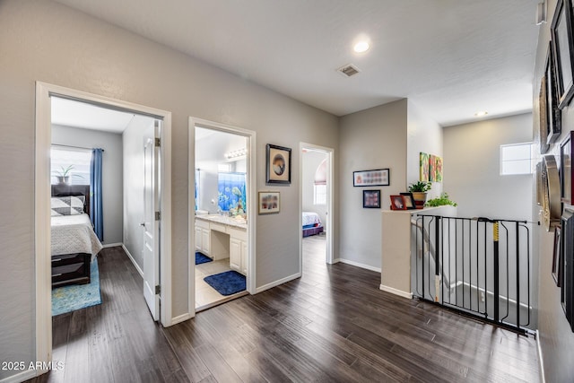 hallway featuring dark wood-style flooring, baseboards, and recessed lighting