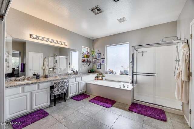 full bath featuring a stall shower, double vanity, a garden tub, and tile patterned floors