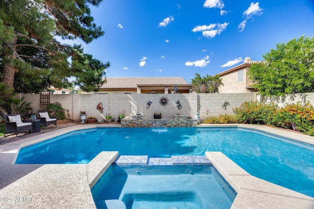 view of pool featuring a pool with connected hot tub and a fenced backyard