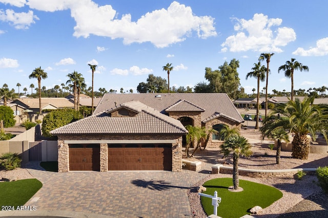 3507 N Snead Dr, Goodyear, AZ 85395 - view of front facade with stone siding, a tile roof, an attached garage, driveway, and a residential view