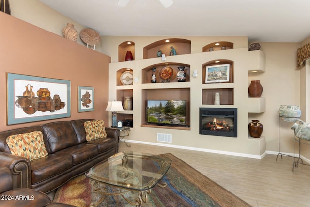 3507 N Snead Dr, Goodyear, AZ 85395 - living room with a glass covered fireplace, baseboards, wood finished floors, recessed lighting, and built in features
