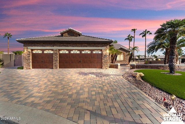 3507 N Snead Dr, Goodyear, AZ 85395 - ranch-style house featuring a tile roof, a garage, decorative driveway, and stone siding