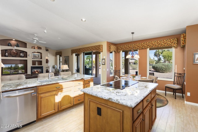 3507 N Snead Dr, Goodyear, AZ 85395 - kitchen with stainless steel dishwasher, open floor plan, black electric cooktop, ceiling fan, and brown cabinetry