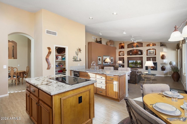 3507 N Snead Dr, Goodyear, AZ 85395 - kitchen with a center island, a sink, open floor plan, black electric stovetop, and arched walkways