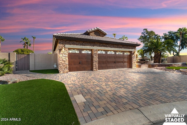 3507 N Snead Dr, Goodyear, AZ 85395 - view of front of property with stone siding, a tile roof, decorative driveway, a garage, and a gate