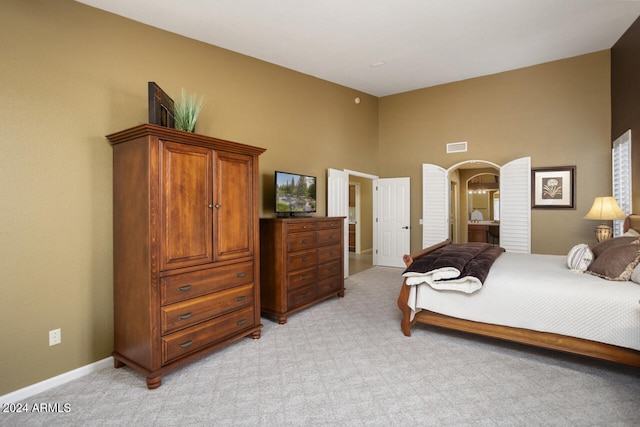 3507 N Snead Dr, Goodyear, AZ 85395 - bedroom featuring light carpet, a high ceiling, arched walkways, and baseboards
