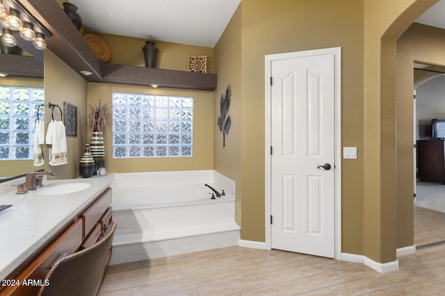 3507 N Snead Dr, Goodyear, AZ 85395 - full bath with vanity, a garden tub, wood finished floors, and baseboards