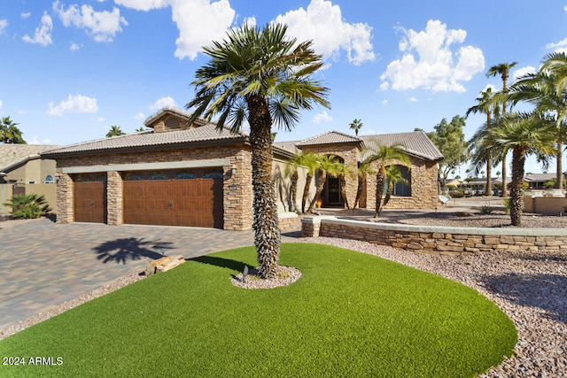 3507 N Snead Dr, Goodyear, AZ 85395 - mediterranean / spanish-style home with stone siding, a garage, a tiled roof, driveway, and a front yard