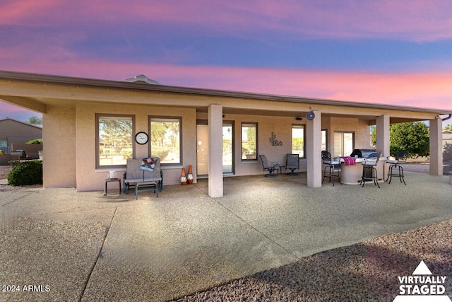 3507 N Snead Dr, Goodyear, AZ 85395 - back of house at dusk with stucco siding and a patio