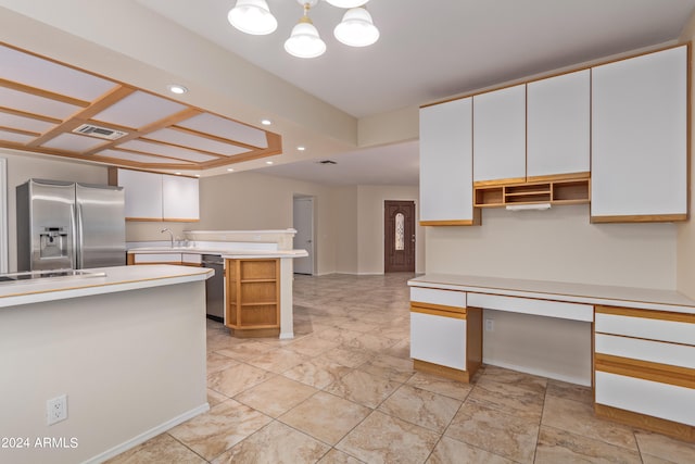 kitchen featuring sink, pendant lighting, white cabinetry, a chandelier, and appliances with stainless steel finishes