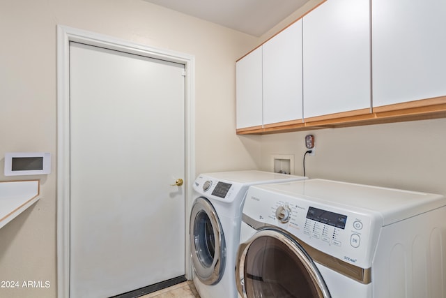 clothes washing area with cabinets, independent washer and dryer, and light tile patterned flooring