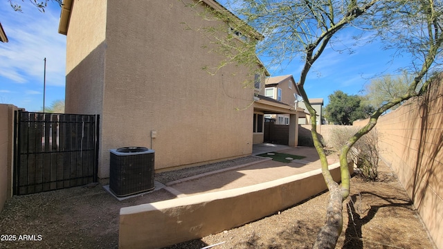 35005 N 30th Dr, Phoenix, AZ 85086 - view of side of home featuring a patio area, stucco siding, central AC, and a fenced backyard