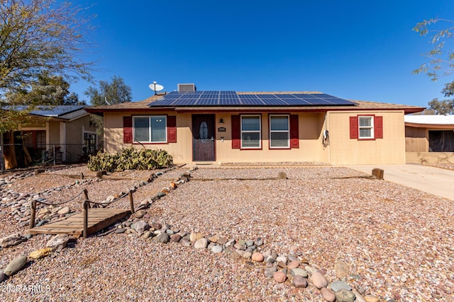 single story home featuring solar panels and fence