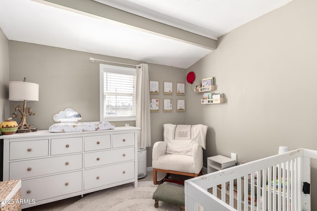 bedroom featuring light carpet, a crib, and lofted ceiling with beams