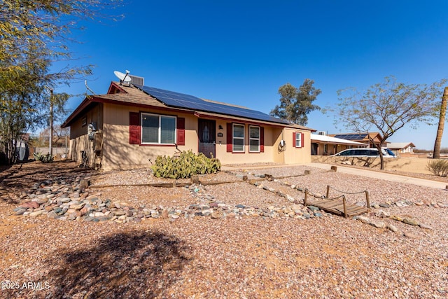 single story home with roof mounted solar panels