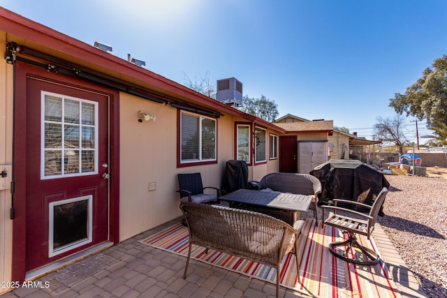 view of patio with a grill, central AC, and fence