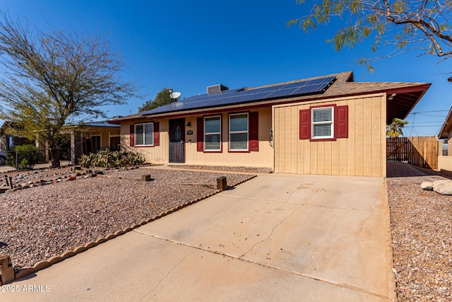 single story home with solar panels and fence