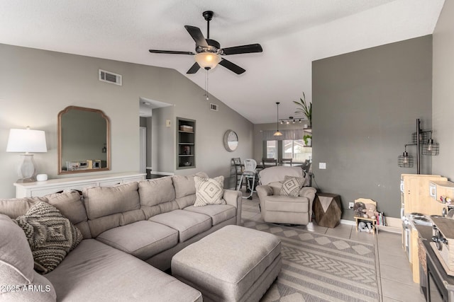 living area featuring light tile patterned floors, a ceiling fan, visible vents, vaulted ceiling, and a textured ceiling