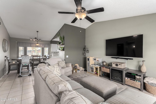 living room with light tile patterned floors, a ceiling fan, and vaulted ceiling