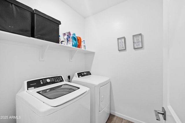 laundry room featuring wood-type flooring and washer and clothes dryer