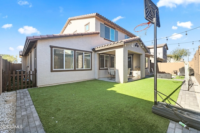 rear view of house featuring a patio area and a lawn