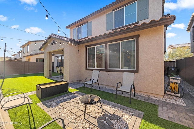 back of property with a patio, a yard, and a fire pit