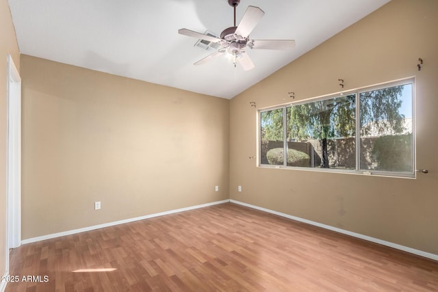 spare room with ceiling fan, lofted ceiling, and light wood-type flooring