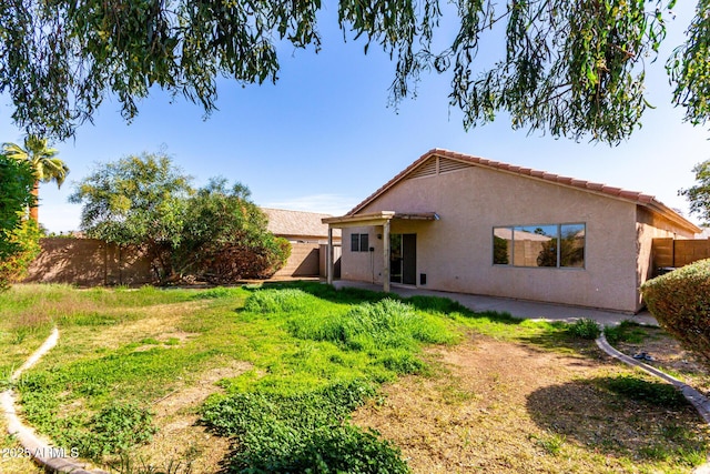 rear view of property featuring a yard