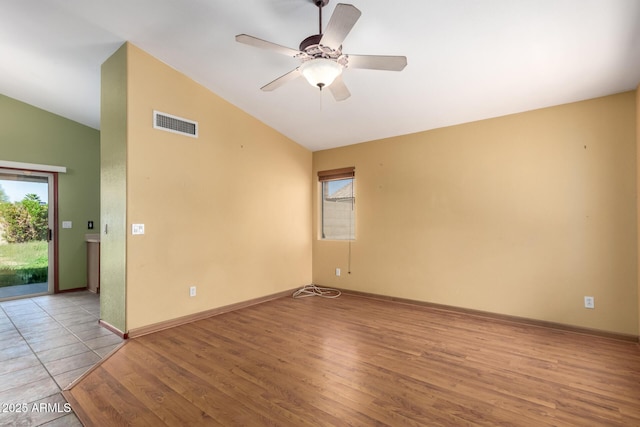 spare room featuring vaulted ceiling, plenty of natural light, and light wood-type flooring