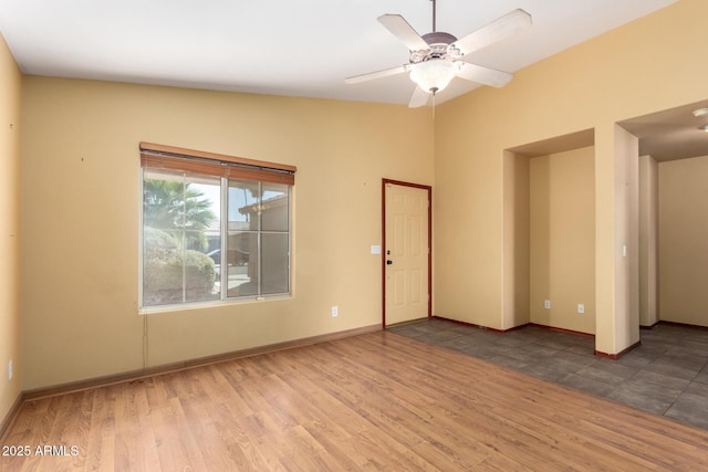 empty room featuring wood-type flooring, vaulted ceiling, and ceiling fan