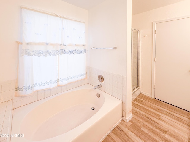 full bath with wood finished floors, a shower stall, and a bath