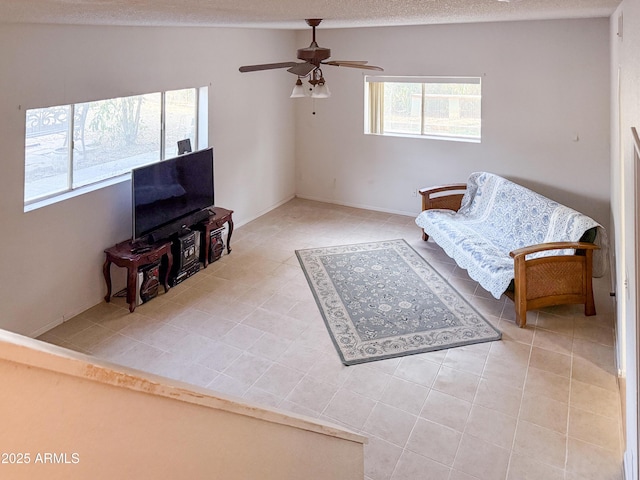 tiled living area featuring a textured ceiling and a ceiling fan