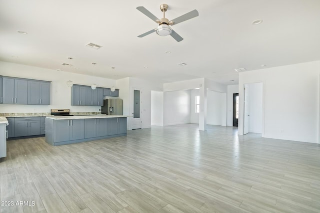 kitchen featuring appliances with stainless steel finishes, ceiling fan, light hardwood / wood-style flooring, gray cabinets, and a kitchen island