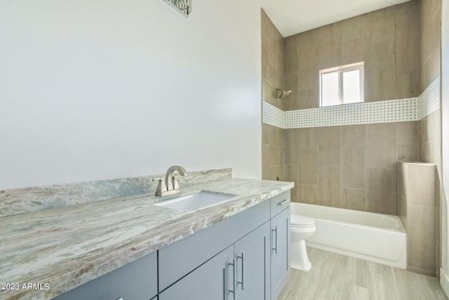 full bathroom featuring vanity, toilet, and tiled shower / bath combo